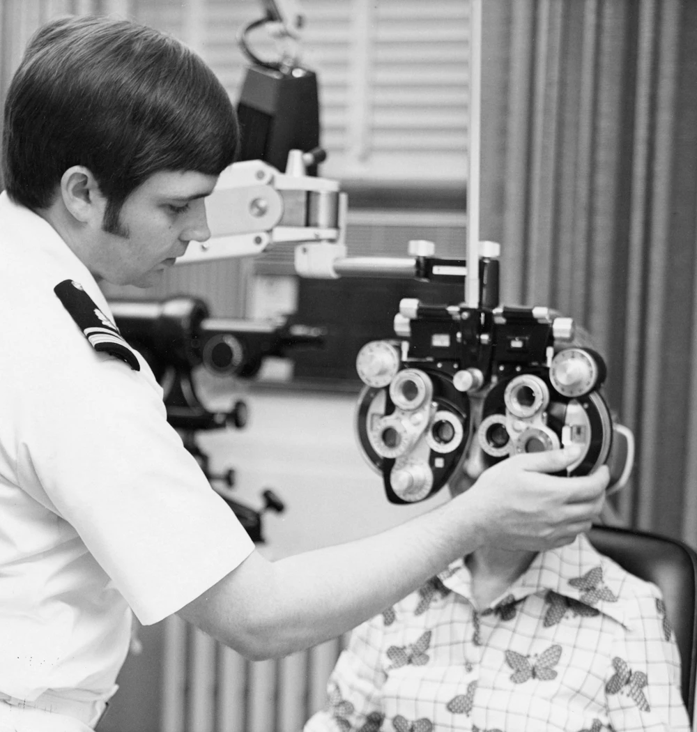 An optometrist examining a patient with a phoropter