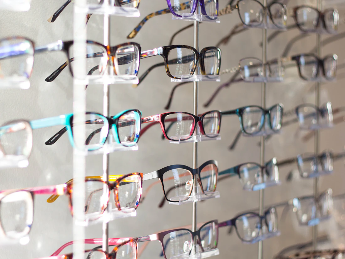 Rows of colorful eyeglass frames on a display wall